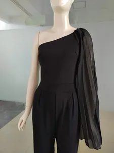 Détail d'une élégante combinaison noire à une épaule avec cape en tulle transparent fluide
