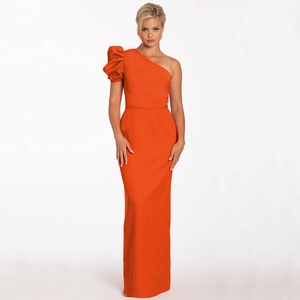 Detailed view of the bright orange one-shoulder evening gown with dramatic bubble sleeve