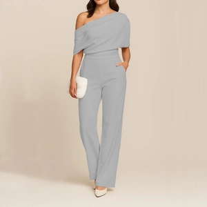 Detail of light grey one-shoulder jumpsuit featuring asymmetric draped pleats and wide legs