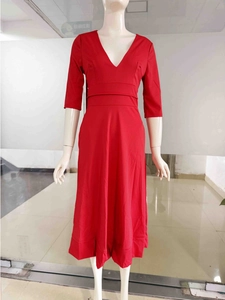 Détail de la robe midi rouge à col en V avec manches trois-quarts et taille large ceinturée