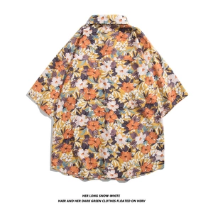 Detail view of the back of a yellow Hawaiian shirt with orange and white hibiscus flowers