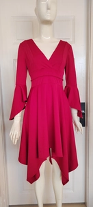 Detail of red V-neck dress featuring flared sleeves and irregular hemline design