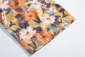 Detail of yellow Hawaiian shirt hem showing tropical floral print and double-stitched sewing
