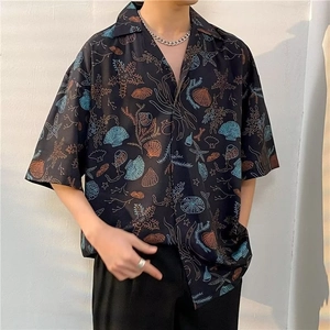 Close-up of Hawaiian floral shirt with starfish and shell print on black fabric