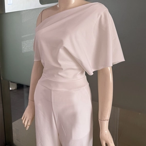 Detailed view of the elegant one-shoulder neckline with ruffles on pink jumpsuit