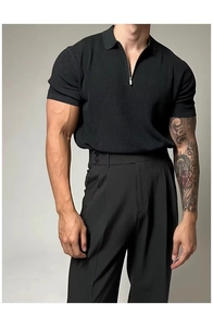 Detail of black knit polo shirt featuring a vertical ribbed texture and metal half-zip neck