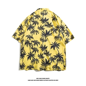 Flat lay of the back view of a yellow Hawaiian shirt featuring black palm tree prints