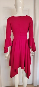 Detail of dark red high-waist dress featuring flared bell sleeves and asymmetric hemline