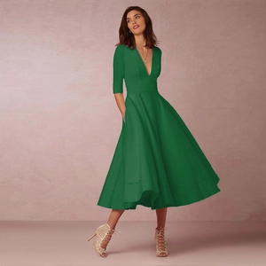 Détail d'une robe mi-longue vert émeraude avec col en V, manches mi-longues et poches