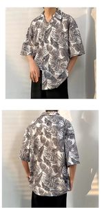 Detail of tropical palm leaf print on oversize Hawaiian short sleeve shirt with shadows