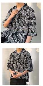 Detail of oversized Hawaiian shirt featuring bold black and white tropical palm leaf prints