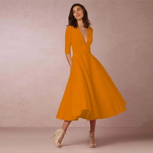 Vue détaillée d'une robe orange à col en V profond avec des poches latérales pratiques