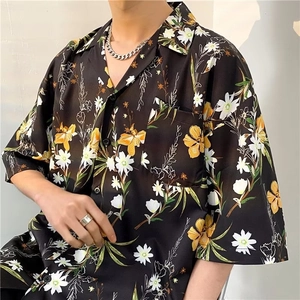 Detail of vintage floral print shirt with yellow flowers and Cuban chain accessory