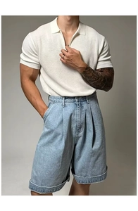 Detail of white knit polo shirt with zipper neckline and light blue denim shorts