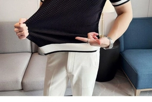 Detail of high-elastic black knit polo shirt featuring striped cuffs and textured fabric