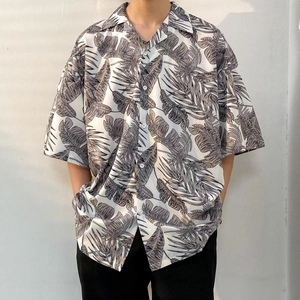 Close-up of tropical leaf print and classic button-down collar on oversized summer shirt