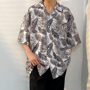 Detail of loose Hawaiian shirt featuring oversized palm leaf print and light white fabric