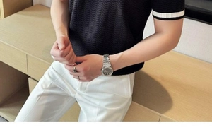 Close-up of black knitted polo shirt featuring wavy texture and white striped cuffs