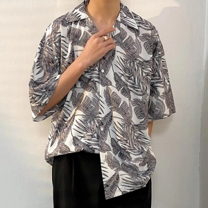 Detail shot of oversized tropical leaf print shirt showing smooth fabric texture and drape