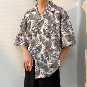 Detail of tropical palm leaf print on white oversized Hawaiian short sleeve shirt