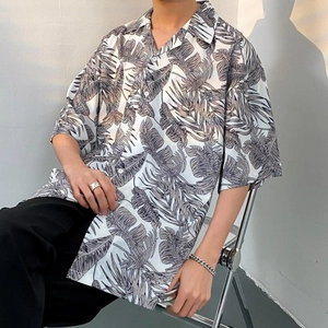 Close-up of oversized Hawaiian shirt featuring tropical leaf patterns and premium fabric texture