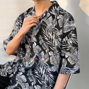 Detail of a Cuban collar short sleeve shirt with black and white tropical leaf print