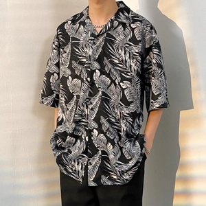 Detailed close-up of a loose fit shirt featuring a black and white palm leaf print pattern