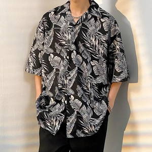 Detail of tropical leaf print on black oversized short sleeve Hawaiian holiday shirt