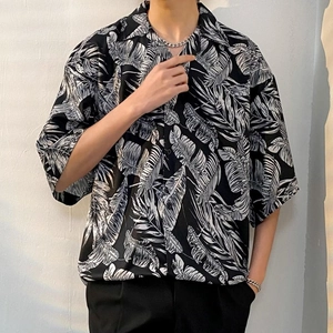 Detailed view of the tropical leaf pattern on a black Cuban collar short sleeve shirt