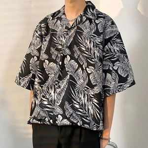 Macro detail of tropical leaf print and classic Cuban collar on a loose summer shirt