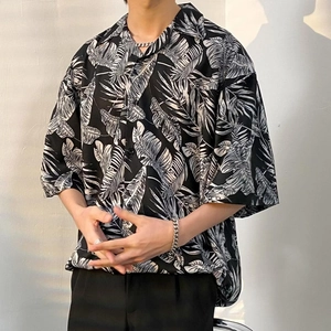 Detail of loose-fit Hawaiian shirt with bold black and white tropical leaf patterns