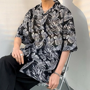 Detail of tropical leaf print on black short-sleeve shirt with creative shadow effects