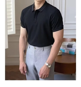 Détail d'un polo noir avec une texture en maille verticale et un col boutonné classique