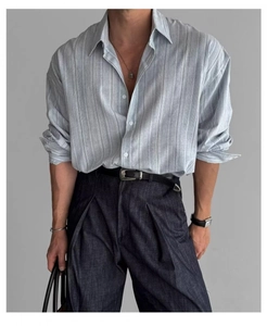 Dettaglio della trama della camicia a righe blu e maniche rimboccate con stile per uomo