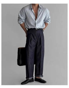 Dettaglio camicia di lino a righe blu con pantaloni in denim larghi e borsa tote nera