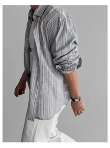 Dettaglio di camicia in cotone e lino a righe grigie con maniche ampie e tessuto traspirante