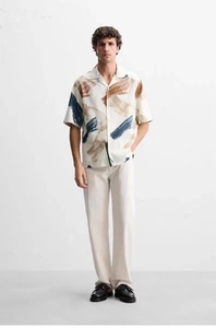 Detail of artistic abstract print on short sleeve shirt with high drape texture
