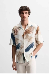 Detailed close-up of Cuban collar and artistic abstract print on casual short sleeve shirt