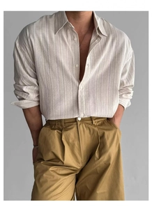 Dettaglio del tessuto della camicia a righe in cotone lino e dei pantaloni kaki casual