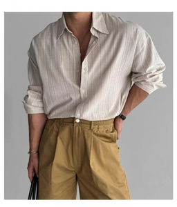 Dettaglio della trama di una camicia a righe da uomo con pantaloni kaki casual