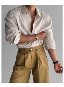 Dettaglio camicia vintage in lino a righe con pantaloni a pieghe giallo senape