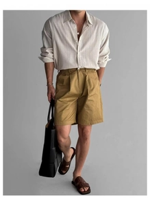 Dettaglio camicia a righe in cotone e lino con pantaloncini a pieghe giallo senape