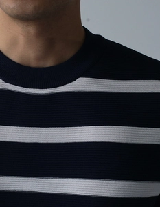 Detail von blau-weiß gestreiftem Strickhemd mit Fokus auf die gerippte Ausschnittstruktur