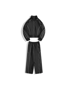 Détail d'un ensemble de survêtement noir avec liseré blanc et veste à col montant