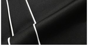 Détail du tissu de sport noir avec passepoil blanc et texture de tissage délicate