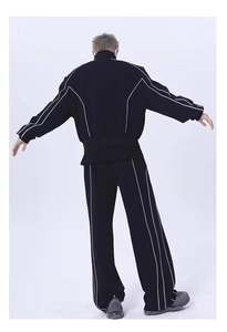 Détails d'un ensemble de sport noir pour homme avec bandes blanches sur la veste et pantalon
