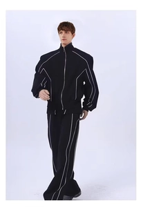 Détail d'un survêtement noir avec veste à col montant et bandes latérales blanches