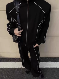 Détail d'un survêtement noir pour homme avec liserés blancs et veste zippée montante