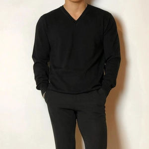 Detailansicht eines schwarzen Herren-V-Pullovers mit Rippbündchen und feiner Textur