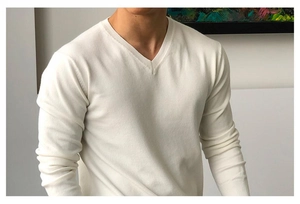 Detail eines weißen Strickpullovers mit V-Ausschnitt, feiner Textur und schmaler Passform